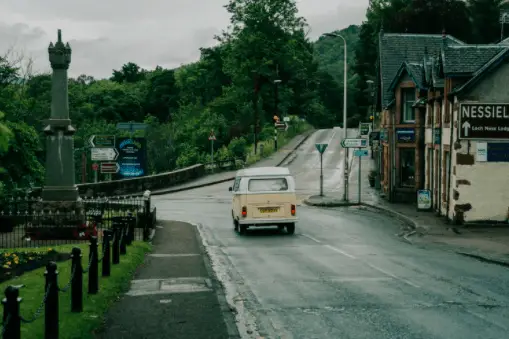 A VW mini van travelling through a small village near by Loch Ness in Scotland. drumnadrochit restaurant. Affric Kintail Way. Loch Ness 360. Loch Ness Monster. Nessie. Great Glen Way. Fort Augustus Walks. Things to do near Loch Ness