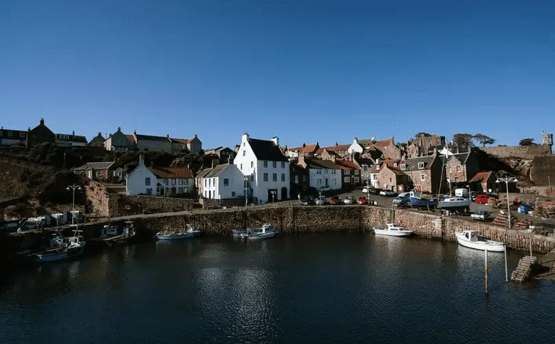 View of the port at Crail, water in the foreground with houses in the middle and the sky is blue in the back ground. East Neuk of Fife