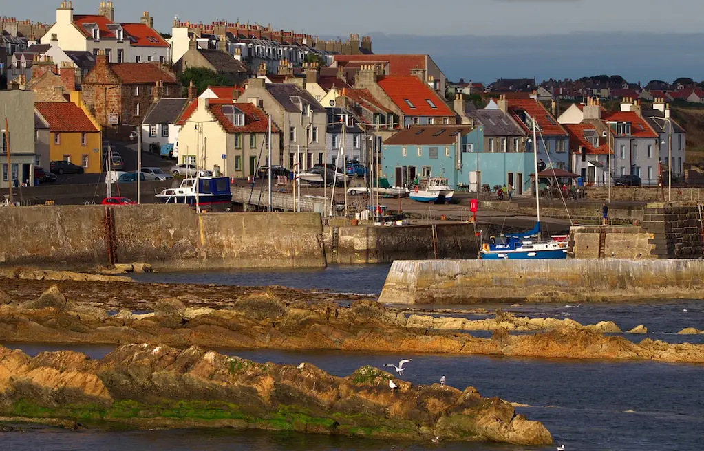 Photo of the coast of St Monans, water in the foreground, with fishermen houses in the background.