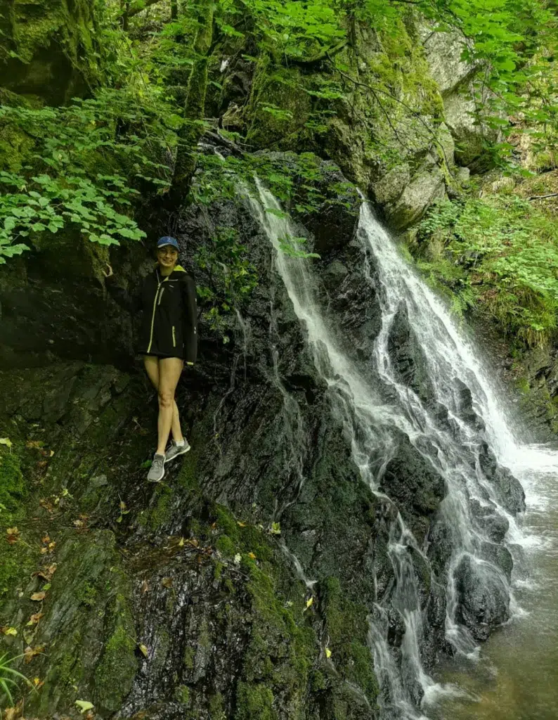 Girl standing in front of waterfall at Fairy Glen