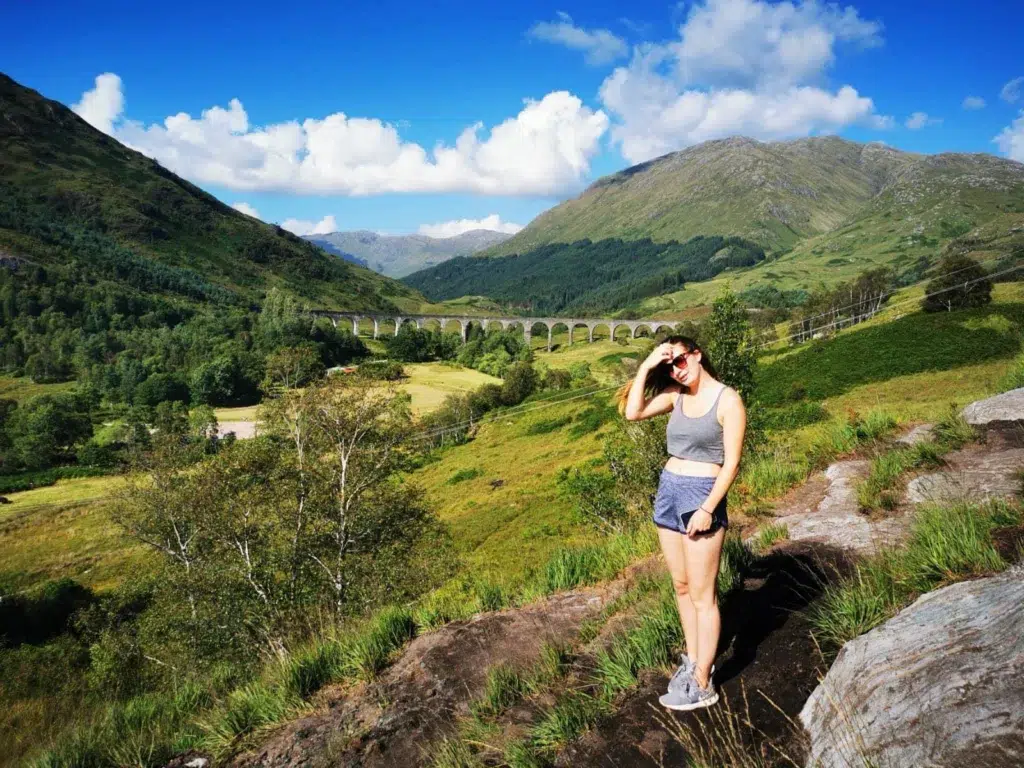 Person standing in Glenfinnan Valley with Glenfinnan Viaduct in the background